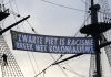 Activisten hangen 'zwarte Piet is racisme' banner op VOC-schip Amsterdam